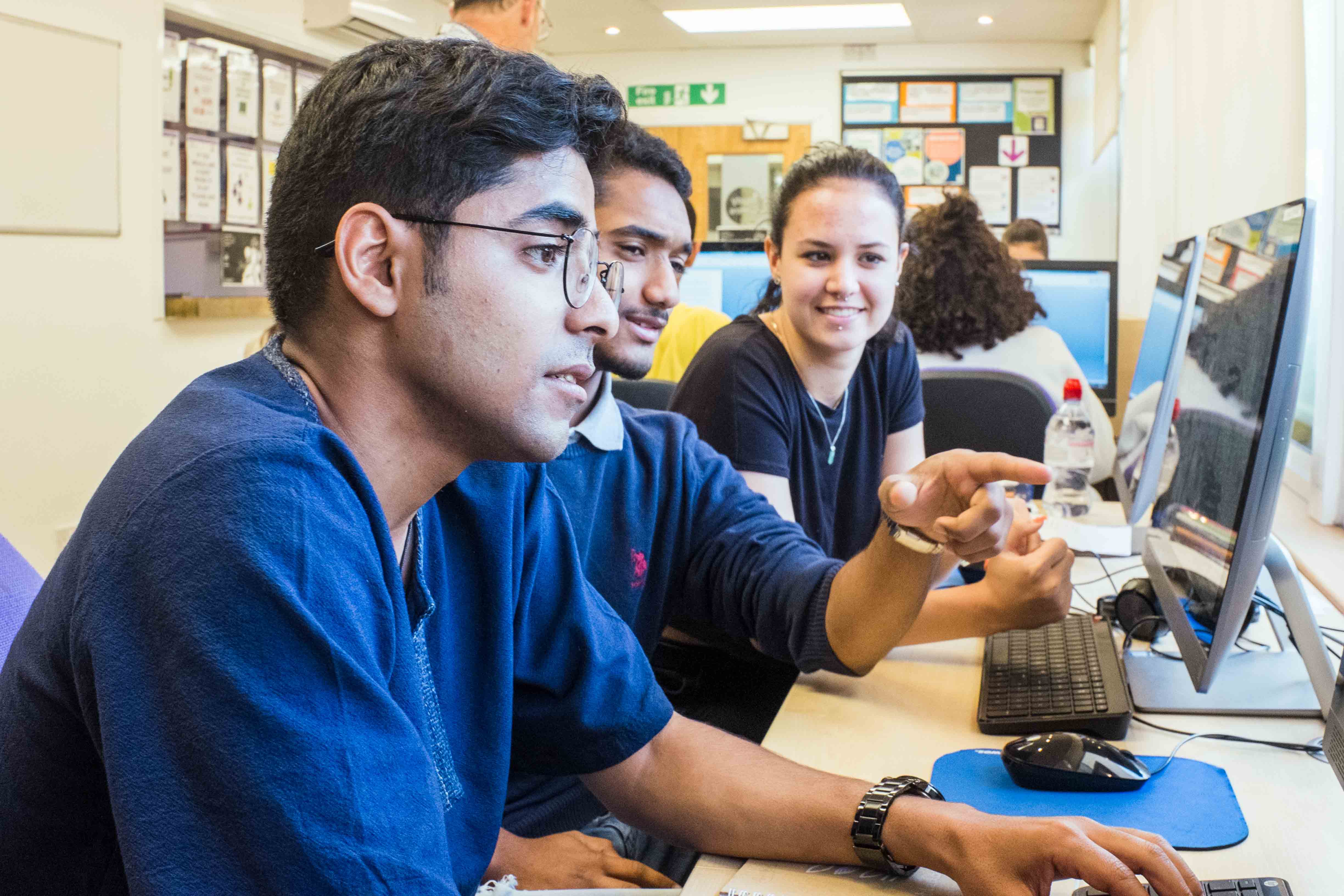 student studying at desk by computer